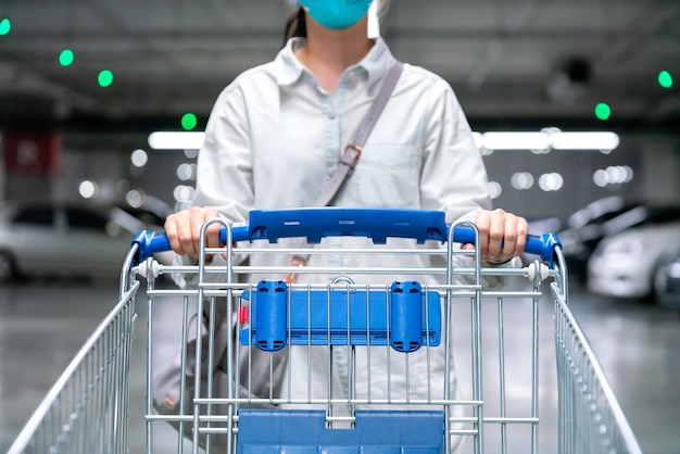 Carro de compras o carrito de mujer feliz en el estacionamiento del mercado fresco en la tienda del supermercado