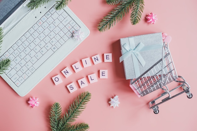 Carro de compras con regalo y laptop