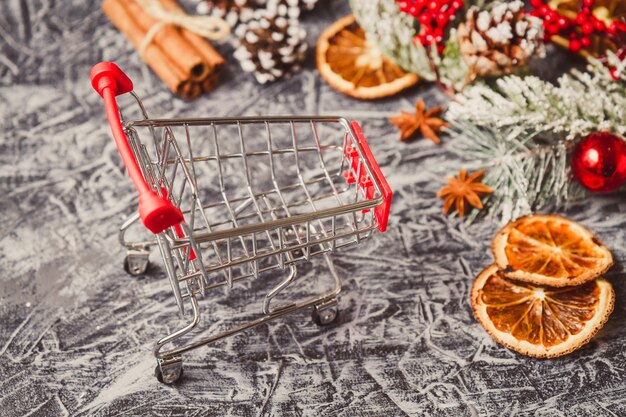 Carro de compras con regalo o presente en mesa de hormigón.