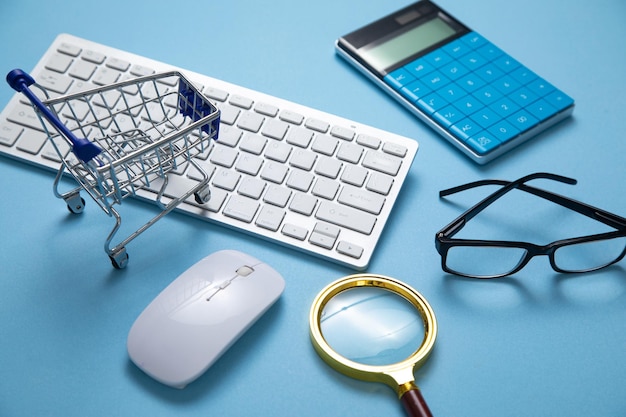 Carro de compras con teclado de computadora y objetos comerciales