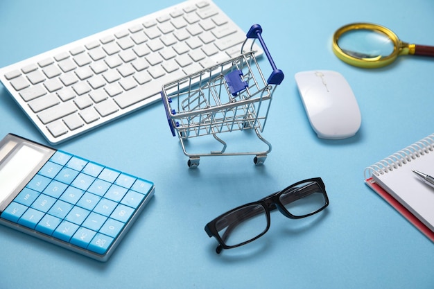 Foto carro de compras con teclado de computadora y objetos comerciales