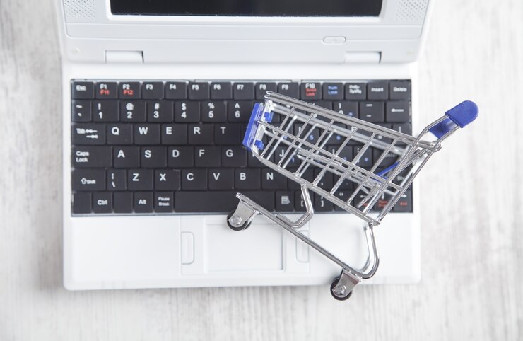 Foto carro de compras en el teclado de la computadora portátil. las compras en línea