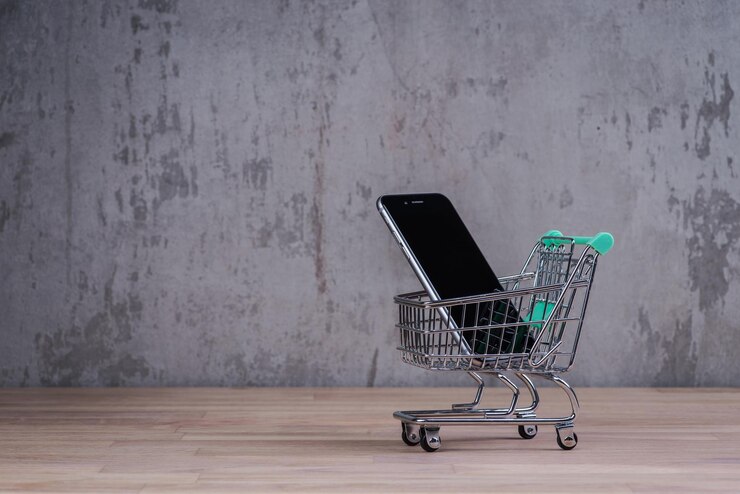 Foto carro de compras con teléfono inteligente dentro de la mesa de madera