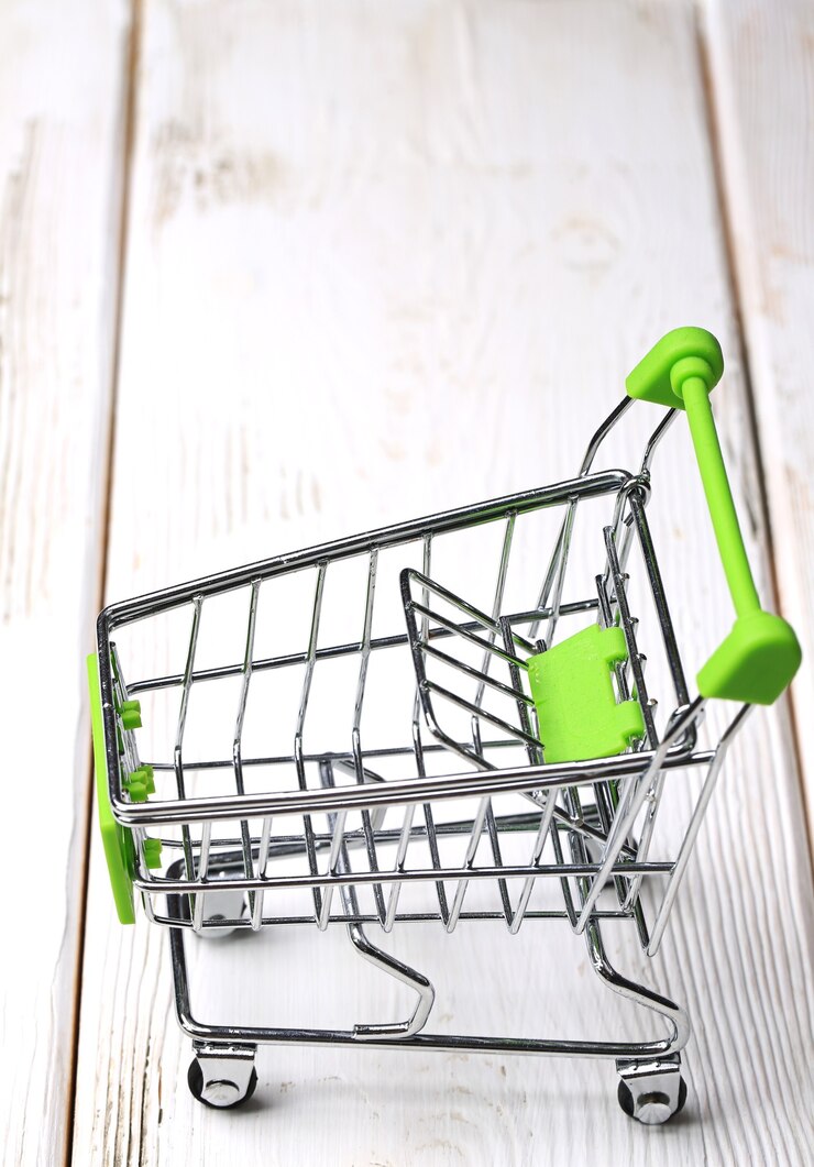Foto carro de compras vacío sobre un fondo de madera blanca