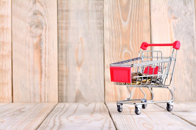 Carro de compras vacío único sobre fondo de madera