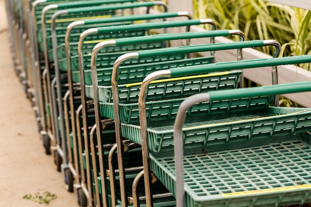 Carro de compras verde grande en una fila.