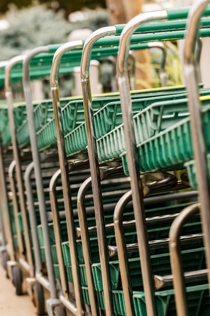 Carro de compras verde grande en una fila.