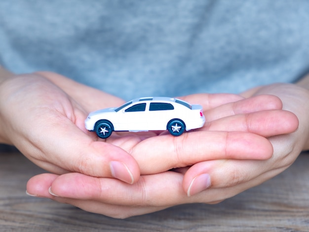 Foto carro de brinquedo branco nas mãos das mulheres