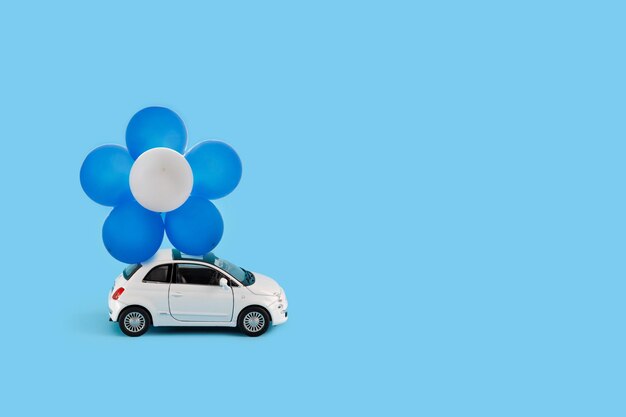 Carro de brinquedo com balões azuis e brancos conceito do dia da independência de israel
