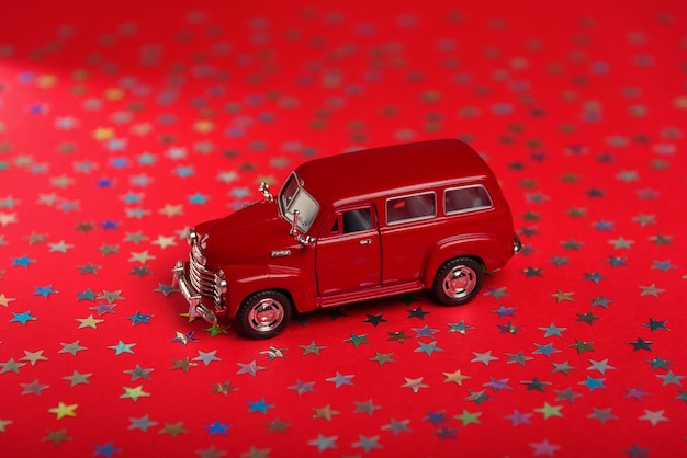 Carro de brinquedo infantil em estrelas coloridas e superfície vermelha