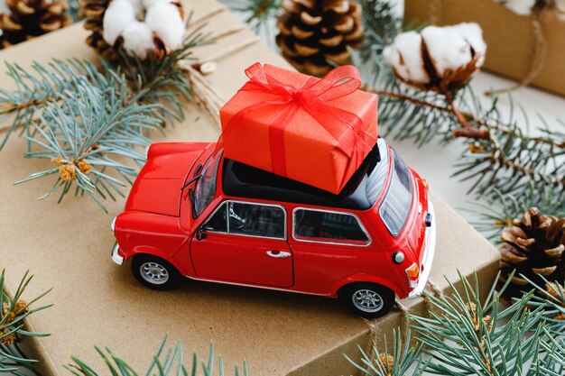 Carro de brinquedo vermelho com caixa de presente vermelha de Natal