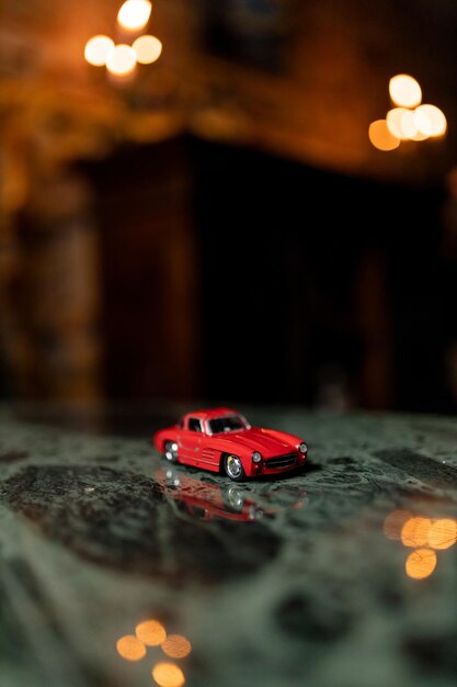 Foto carro de brinquedo vermelho com fundo de luzes bokeh