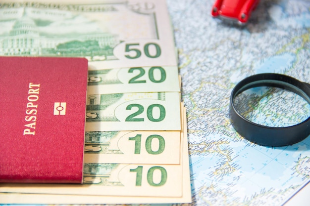 Carro de brinquedo vermelho de lupa de passaporte e dinheiro no mapa Conceito de planejamento orçamentário