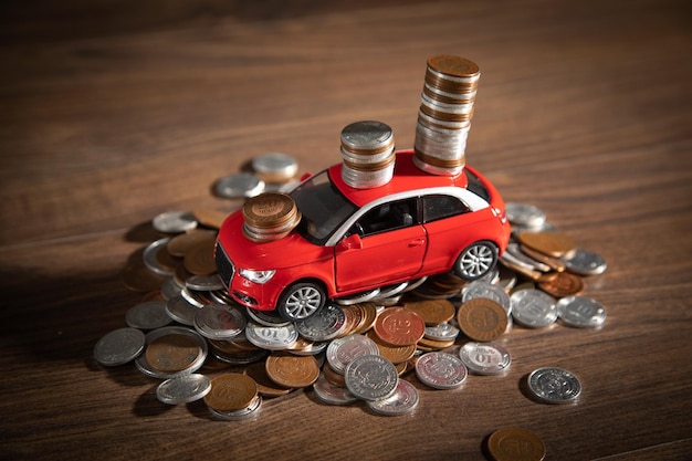 Carro de brinquedo vermelho e moedas na mesa