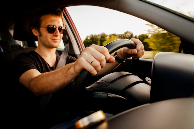 Carro de condução masculino na estrada