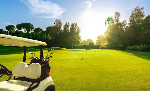 Carro de golfe em um campo de golfe ao pôr do sol na Turquia Belek