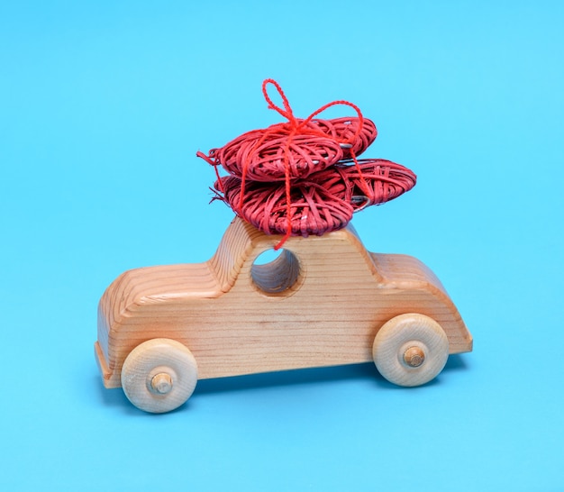 Carro de madeira pequeno infantil carrega um coração vermelho de vime