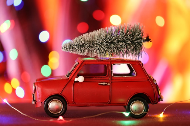 Foto carro de natal com árvore de natal. carro vermelho com uma árvore de natal decorativa