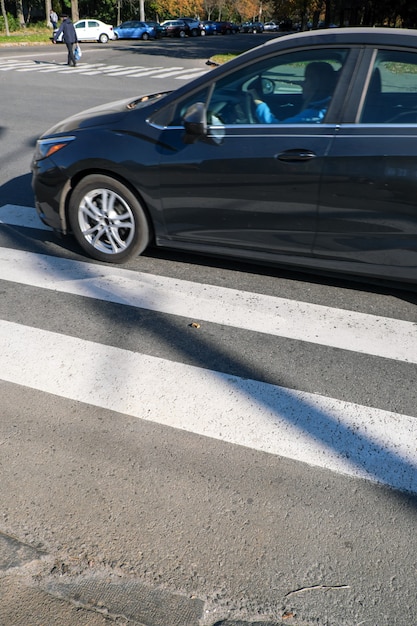 Carro de passageiros na cidade na faixa de pedestres em um dia ensolarado de outono