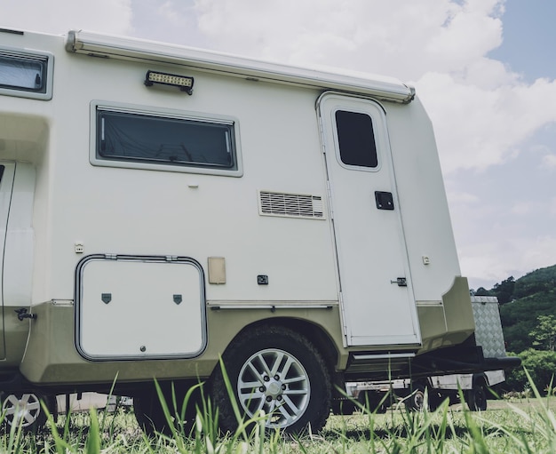 Carro de reboque de acampamento de viagem no chão com grama