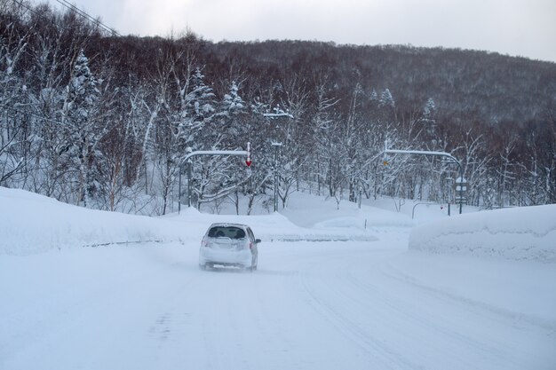 Carro em uma estrada de montanha em um dia nevado