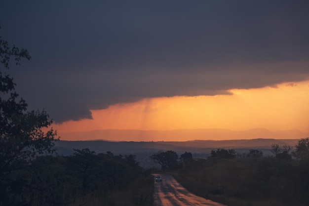 Carro em uma estrada vazia durante o pôr do sol na África
