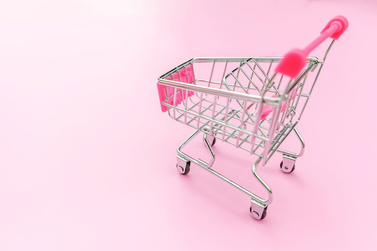 Foto carro de empuje de supermercado pequeño para comprar juguetes con ruedas aisladas en rosa pastel colorido de moda