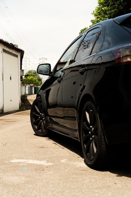 Carro japonês preto completo em uma rua de garagem em um dia ensolarado