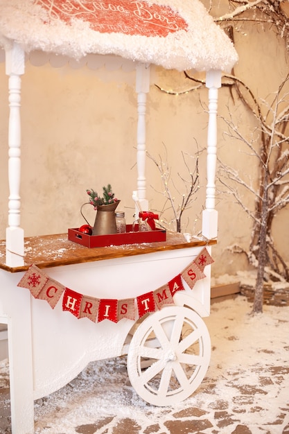 Carro de madera blanco decorativo con dulces navideños.