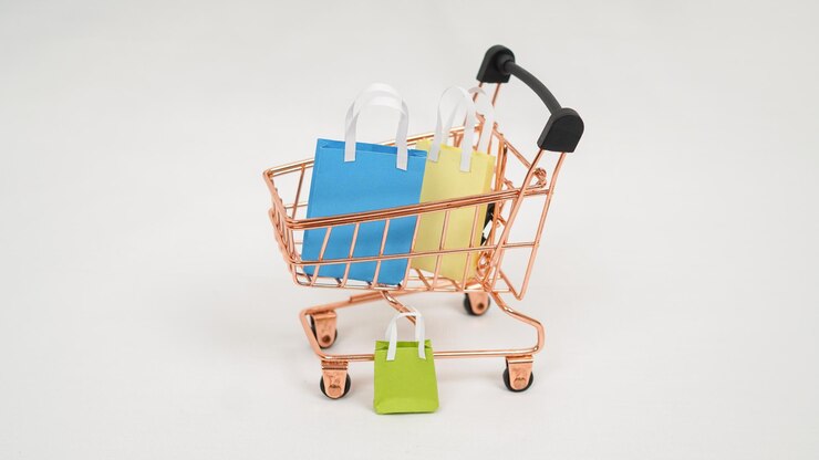 Foto carro en miniatura lleno de cajas de colores y mini bolsas aisladas sobre fondo blanco.