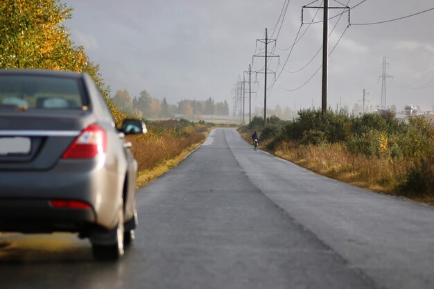 Carro na pista da estrada em um dia chuvoso de outono