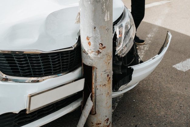 Carro quebrado por acidente, capô amassado e farol rachado ao bater no poste