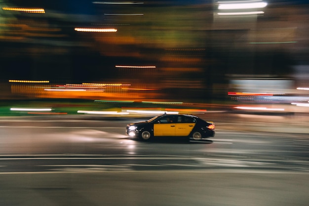 Carro se movendo em estrada iluminada à noite