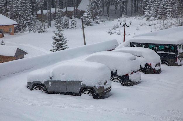 Carro sob uma espessa camada de neve Carros cobertos de neve durante uma nevasca de inverno