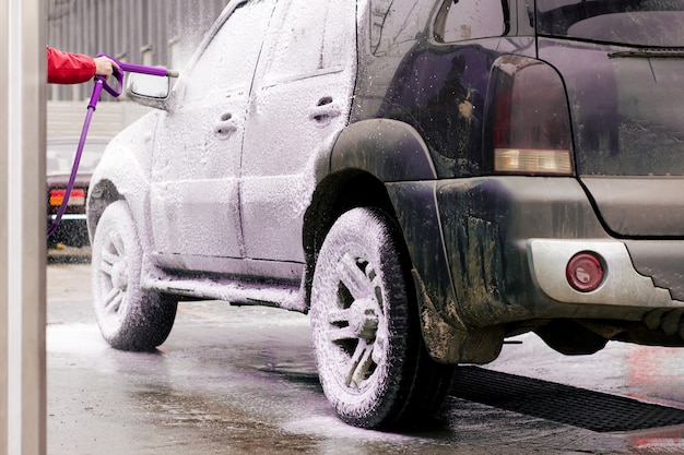 Foto el carro sucio estalla con espuma activa del rociador en el fregadero