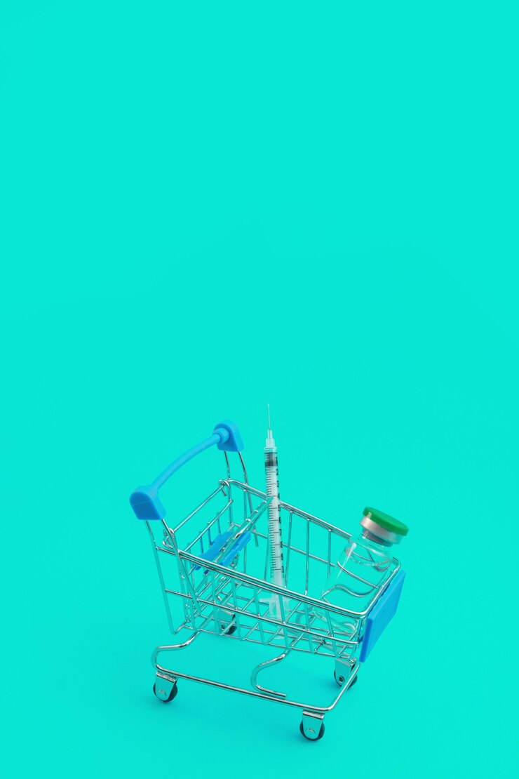 Foto carro de supermercado con jeringas y ampolla aislado