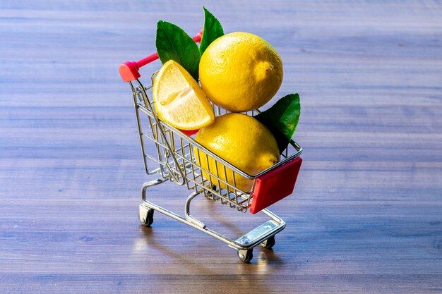 Carro de supermercado con limón y hoja verde