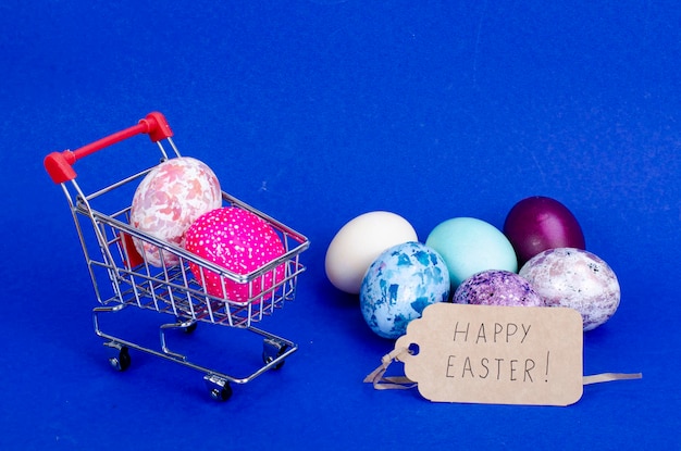 Carro de supermercado lleno de huevos de gallina. Concepto de preparación para Semana Santa, compra de alimentos. Espacio para texto. Foto de estudio