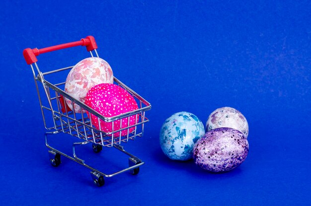 Carro de supermercado lleno de huevos de gallina. Concepto de preparación para Semana Santa, compra de alimentos. Espacio para texto. Foto de estudio