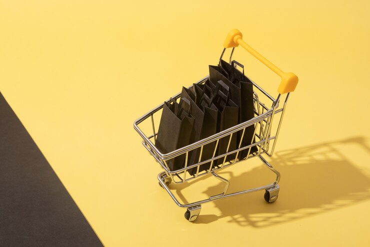 Foto carro de supermercado en miniatura con bolsas de la compra en venta de viernes negro sobre fondo amarillo