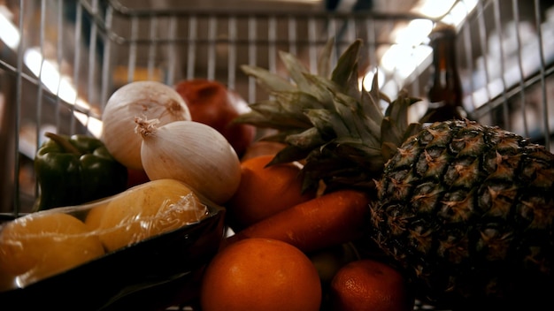 Carro de supermercado en el supermercado comprando diferentes frutas y verduras