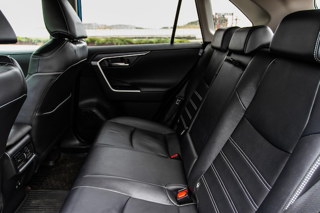 Carro SUV moderno dentro. Assentos de passageiro traseiros em couro preto em um carro de luxo moderno. Assentos de couro confortáveis.