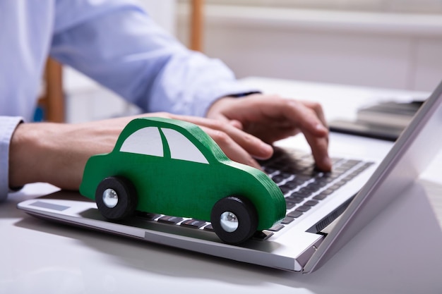 Carro verde no teclado do laptop