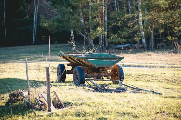 Carro verde viejo y carro de caballos en un campo en un pueblo