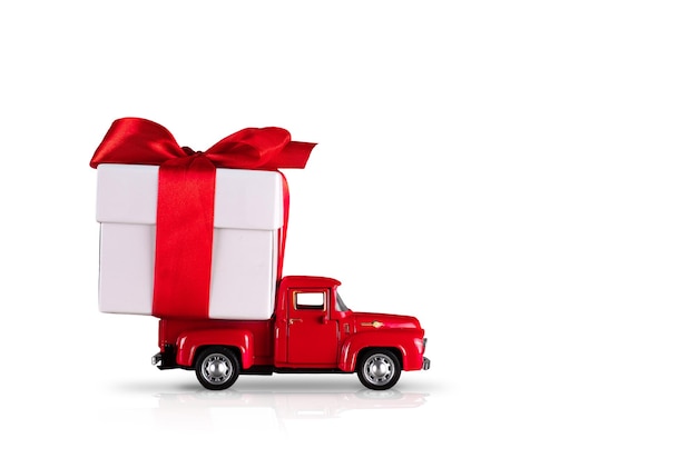 Carro vermelho com uma caixa de presente em um fundo branco isolado. O conceito é a entrega de presentes para os feriados, Dia dos Namorados, Dia Internacional da Mulher, 14 de fevereiro, 8 de março. Compras, venda