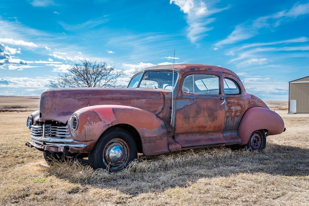 Carro vermelho vintage abandonado nas pradarias em Saskatchewan