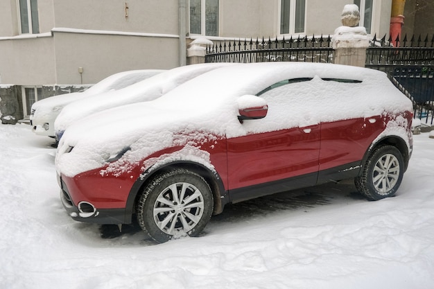 Carros cobertos de neve estacionados na rua