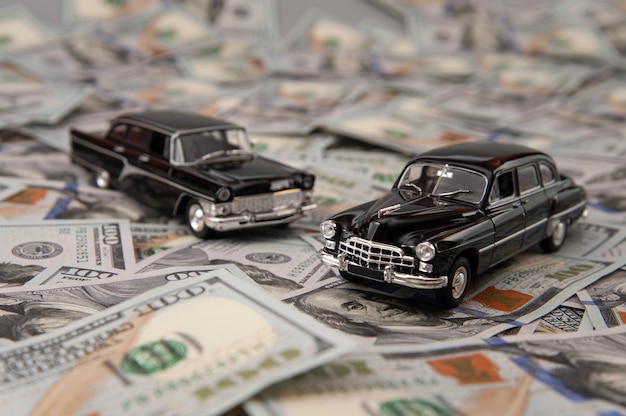 Foto carros de brinquedo no fundo de notas de dólar