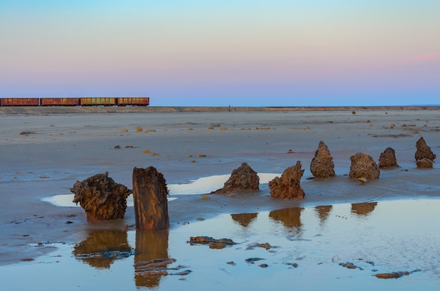 Carros de trem velho enferrujado com estalactites de sal no lago baskunchak