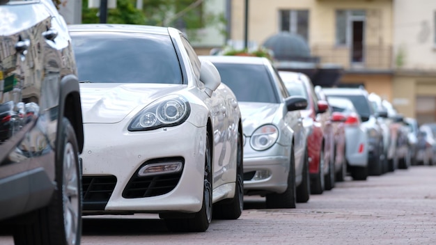 Carros estacionados em linha no conceito de tráfego urbano do lado da rua da cidade